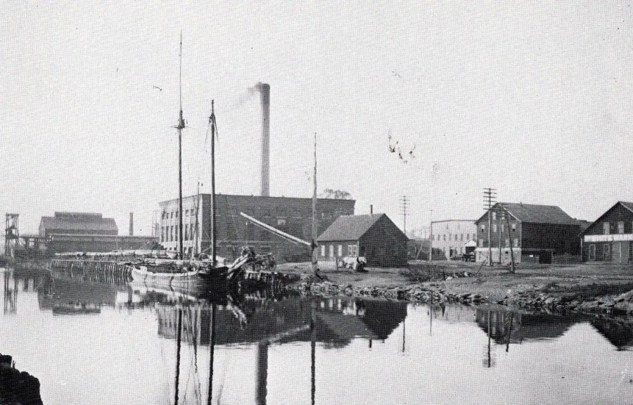 Historic photograph of the Weir Village riverfront with mills and schooners